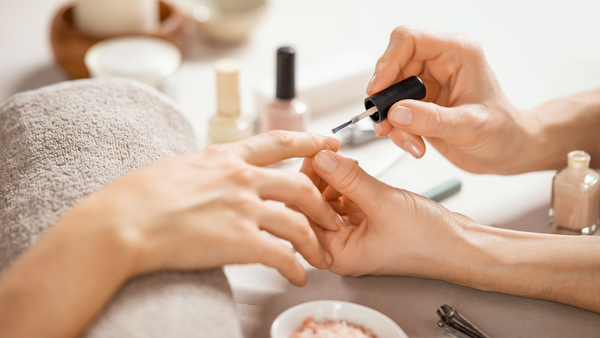 Patient gently applying non toxic varnish to nails as part of chemotherapy nail care routine